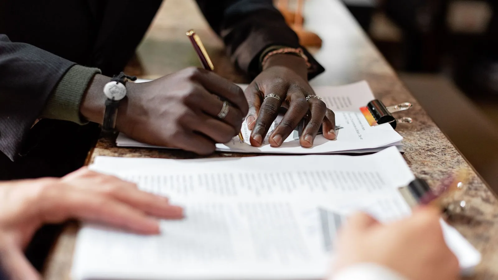 Hands signing a document during a business meeting