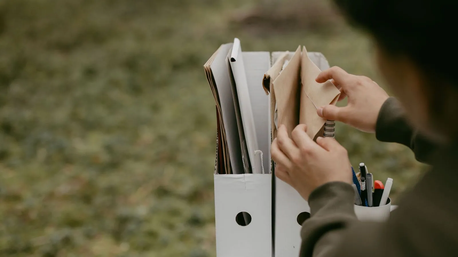 Hands organising papers in a ring binder