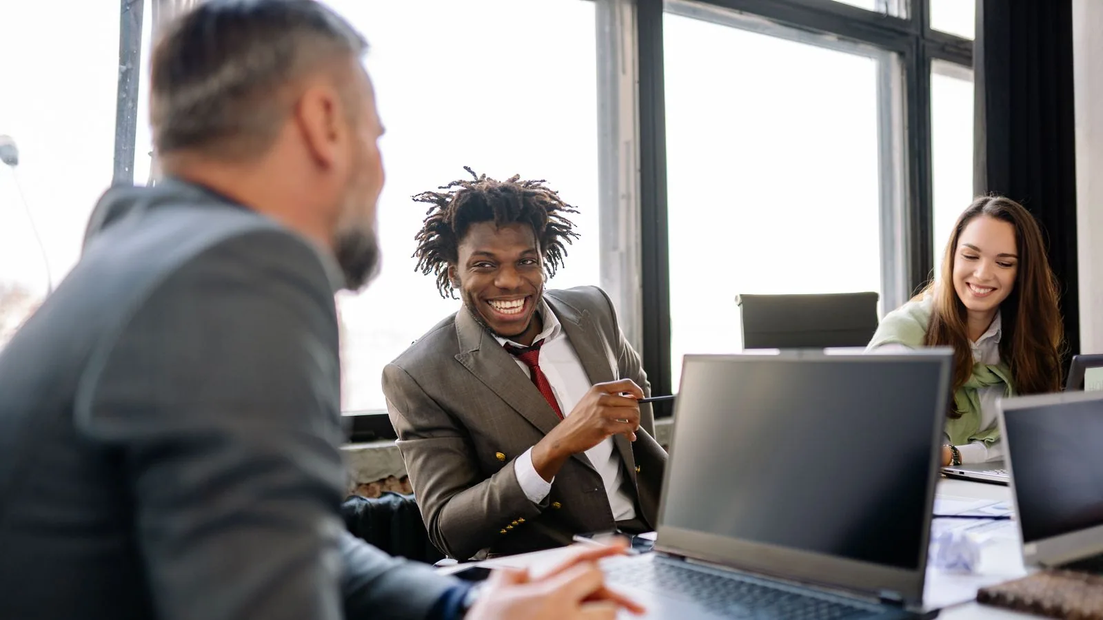 Colleagues discussing work around a laptop