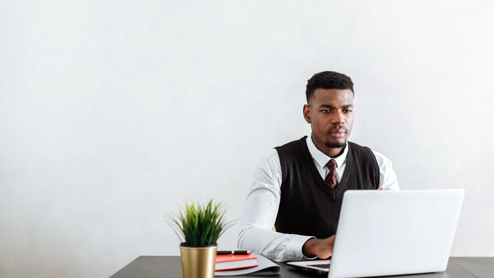 A man working at a laptop at an office table