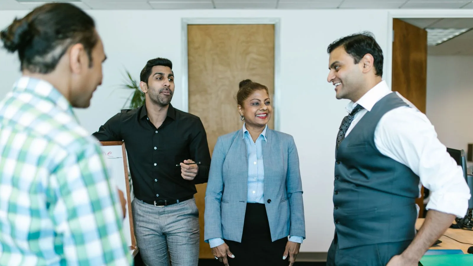 Colleagues discussing work beside their desks