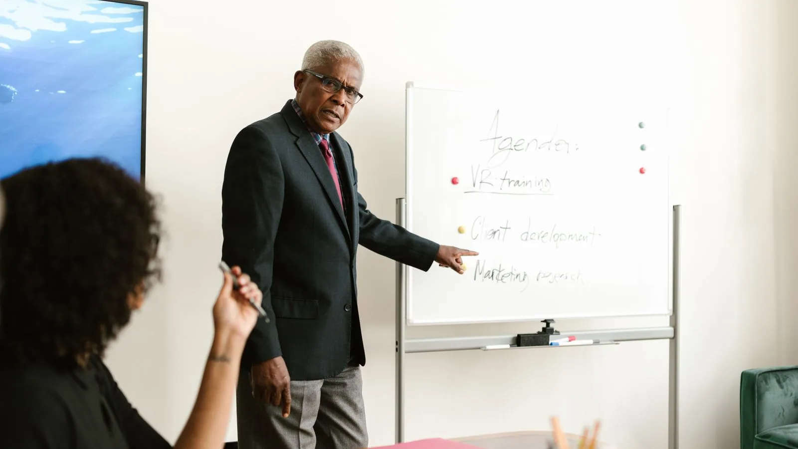 A man explaining planning notes on a whiteboard