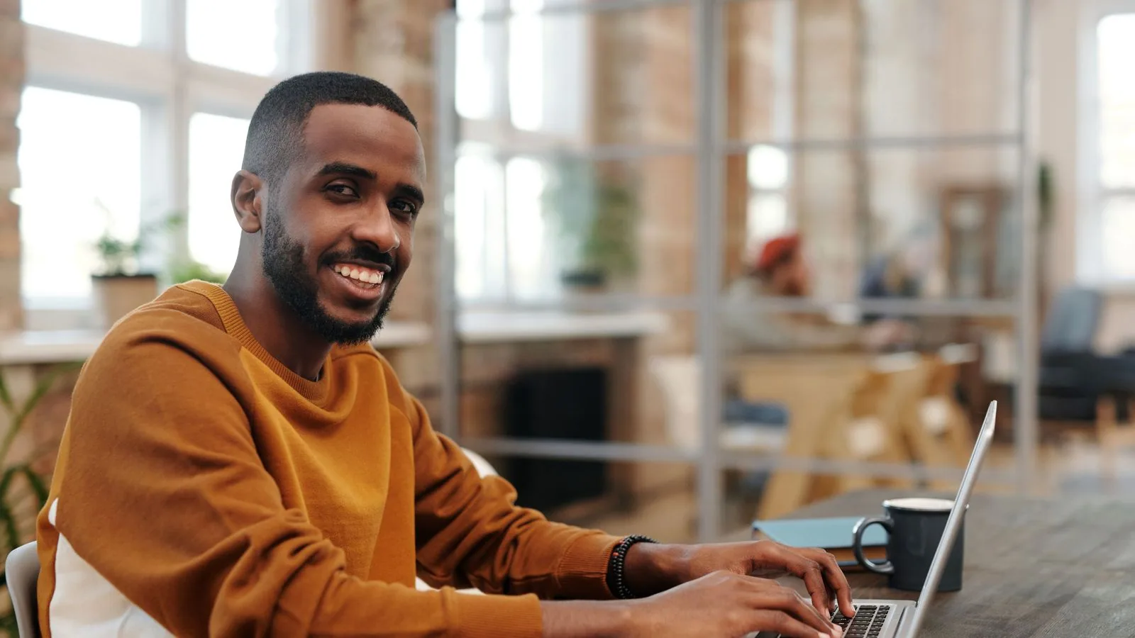 A man using a laptop at a shared work table