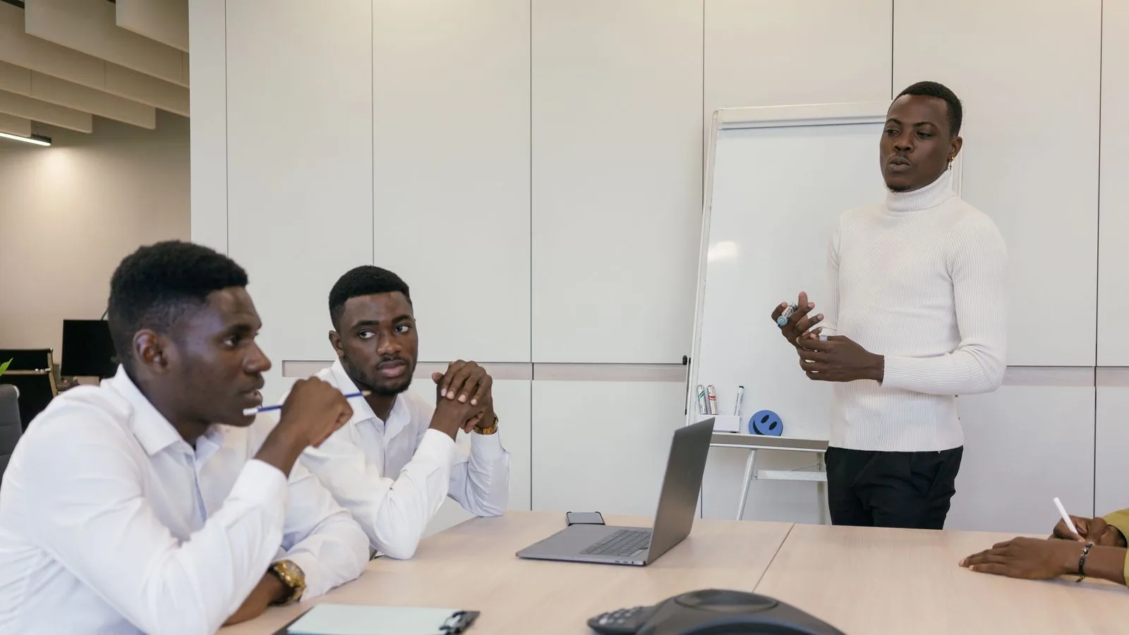 A man leading a discussion with colleagues at a table
