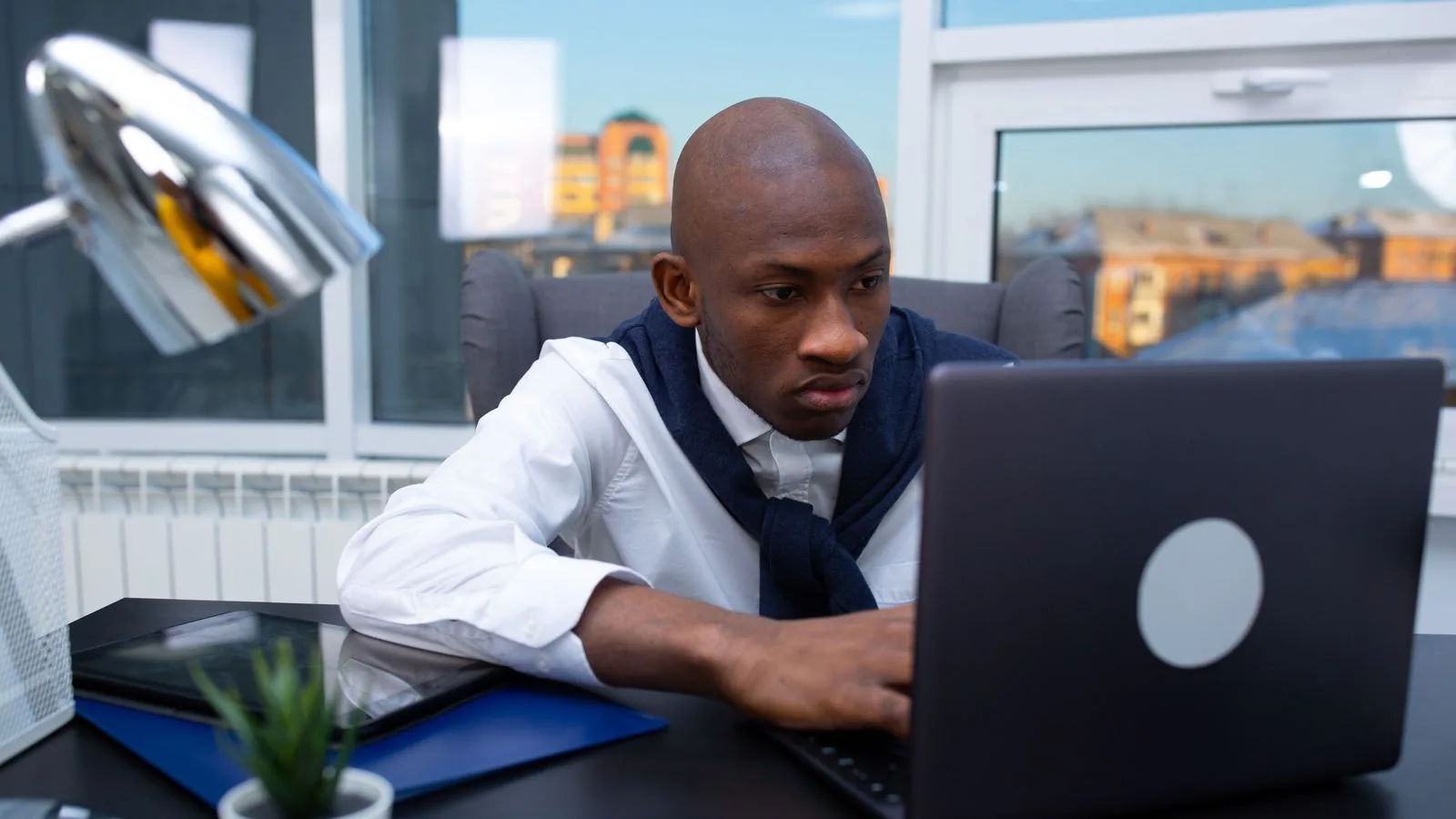 A man using a laptop beside office papers