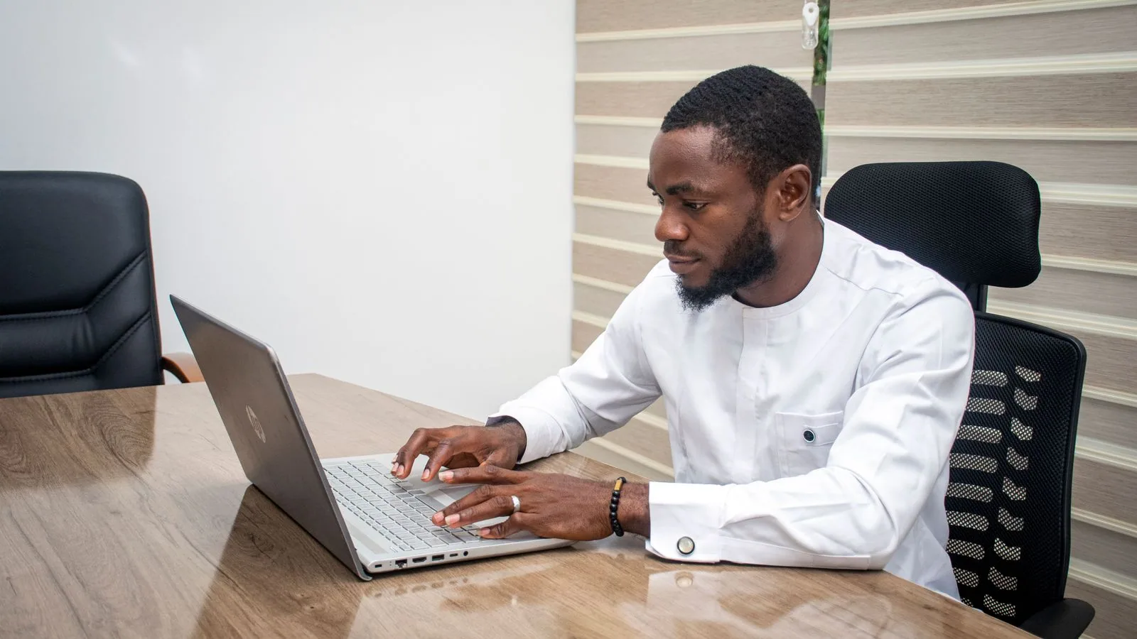 A man working at a laptop at an office desk