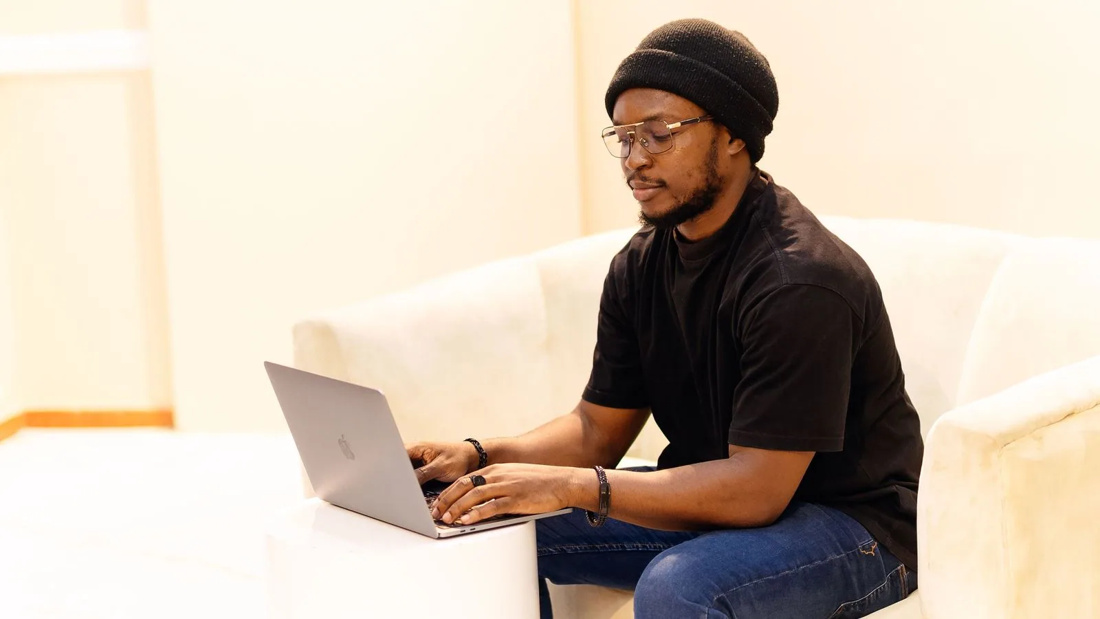 A man using a laptop while seated on a sofa