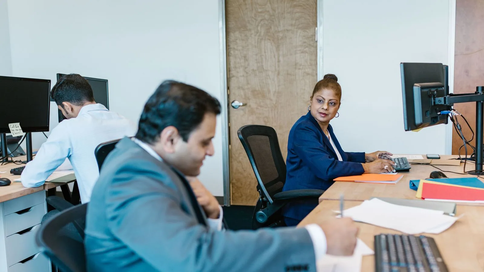 People working at adjacent desks in an office