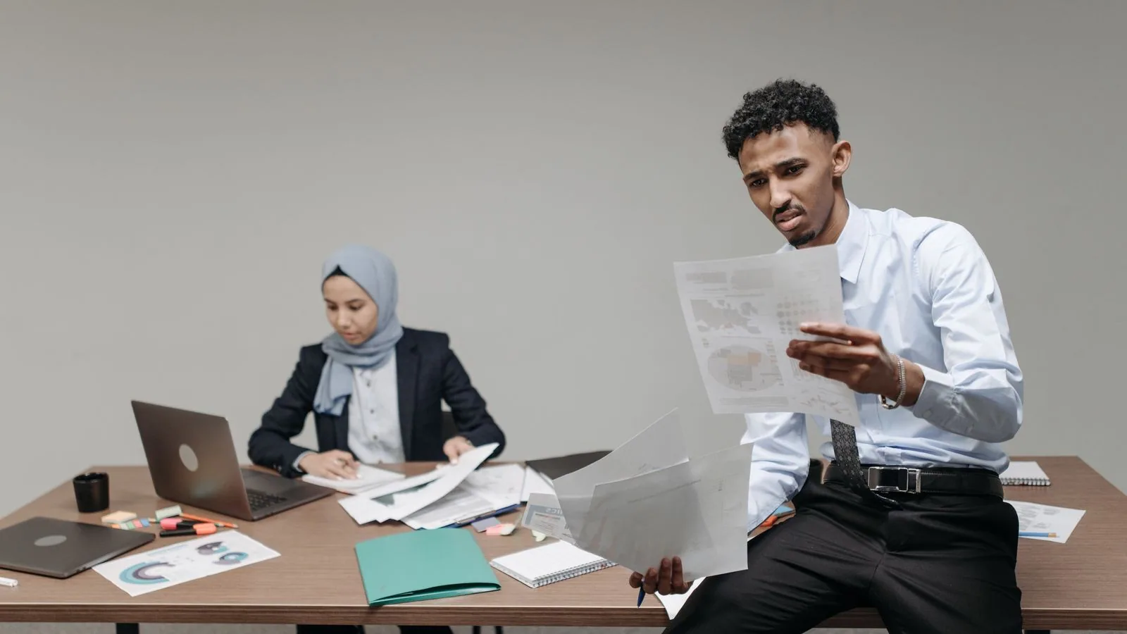 Two colleagues discussing papers in an office