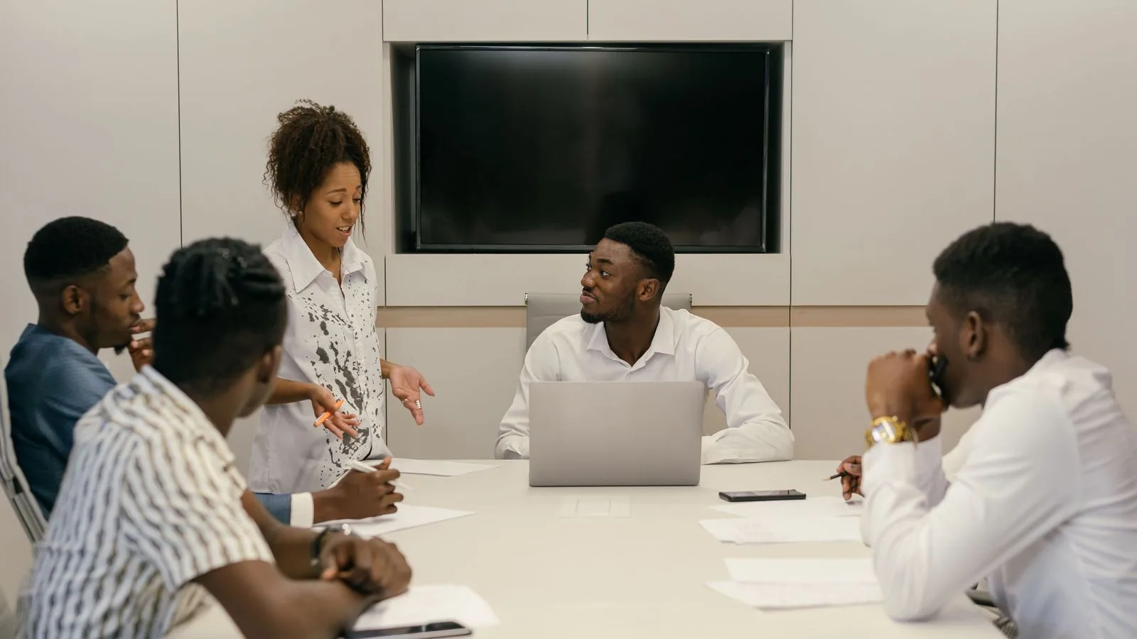 A team discussing information on a laptop at a meeting table