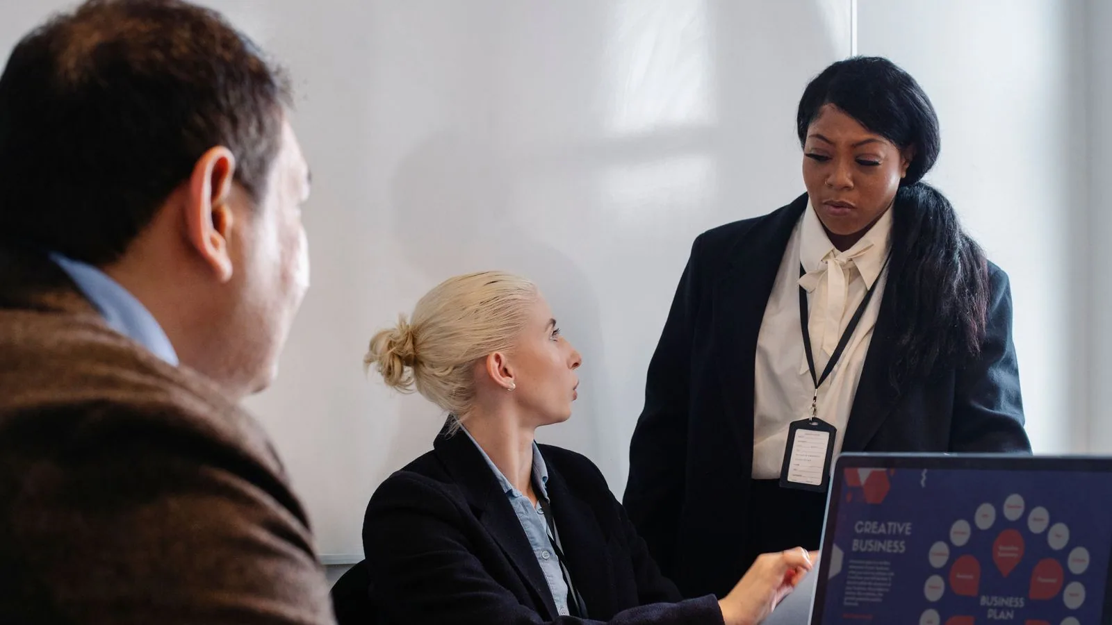 A woman discussing a chart with colleagues at a meeting