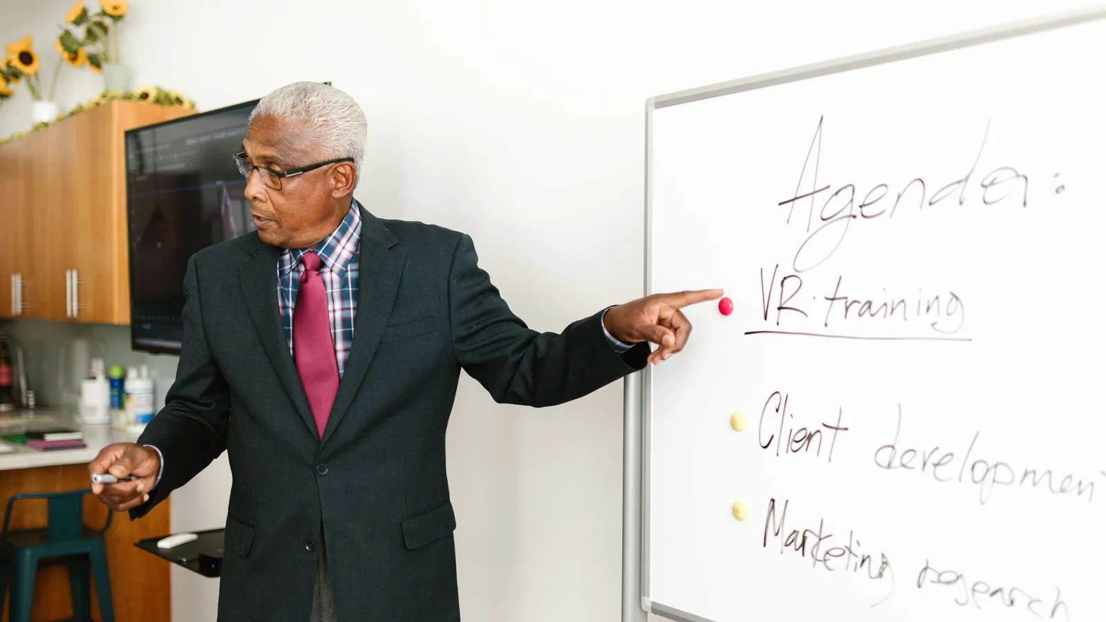 A man explaining whiteboard notes during a business meeting