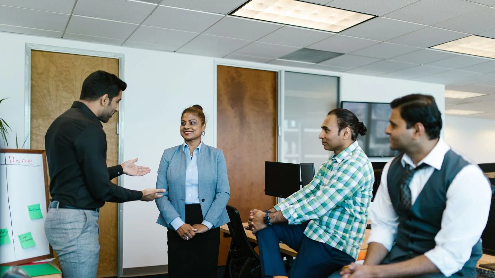 A group of colleagues discussing work in an office