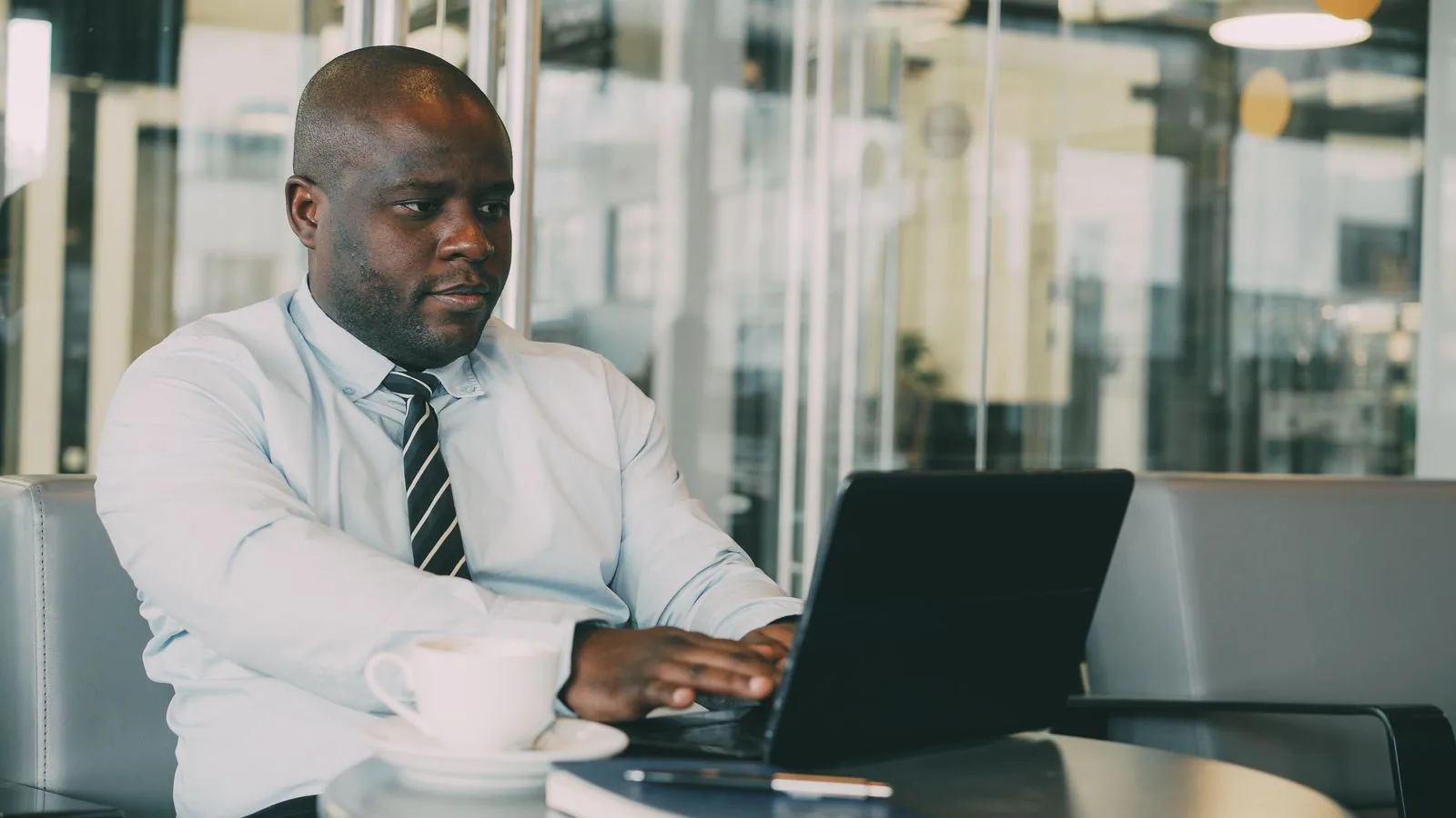 A man checking a laptop at a cafe table