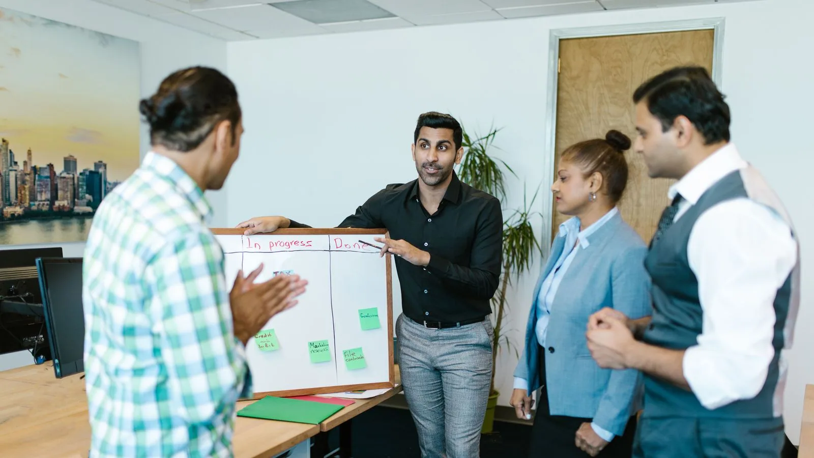 Colleagues discussing a chart on a whiteboard