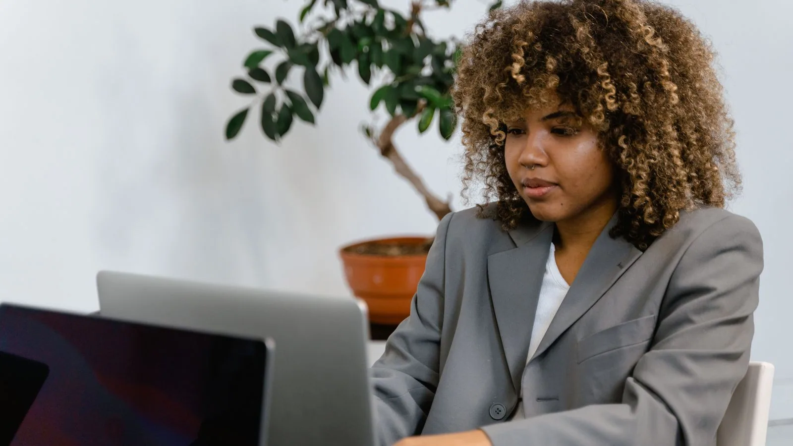 A woman working on a laptop at a desk