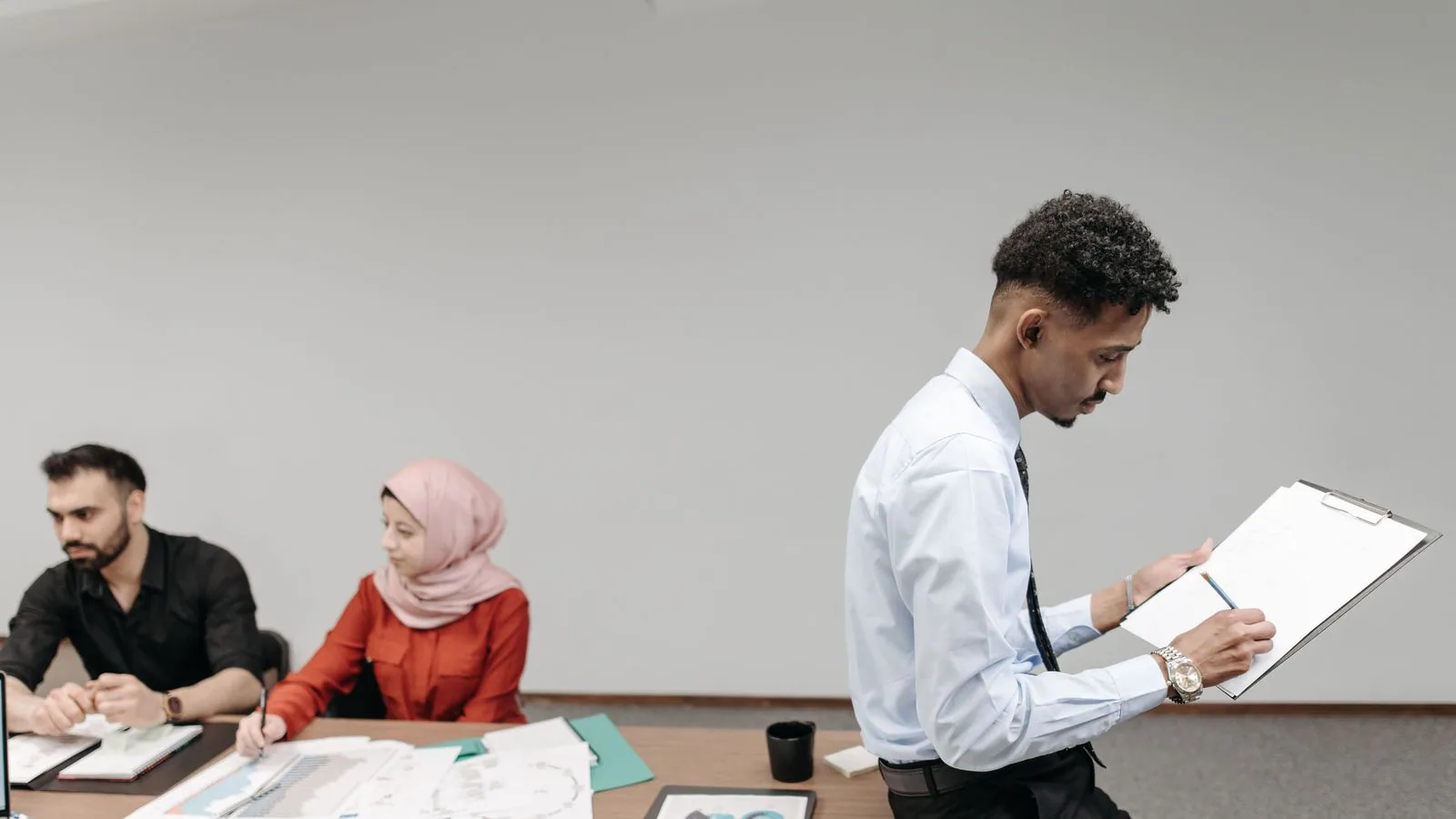 A colleague reviewing a clipboard in a shared office