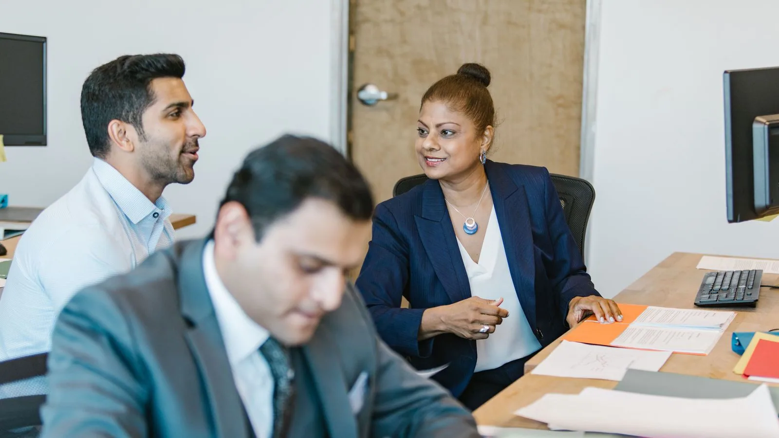 Colleagues reviewing documents at an office desk