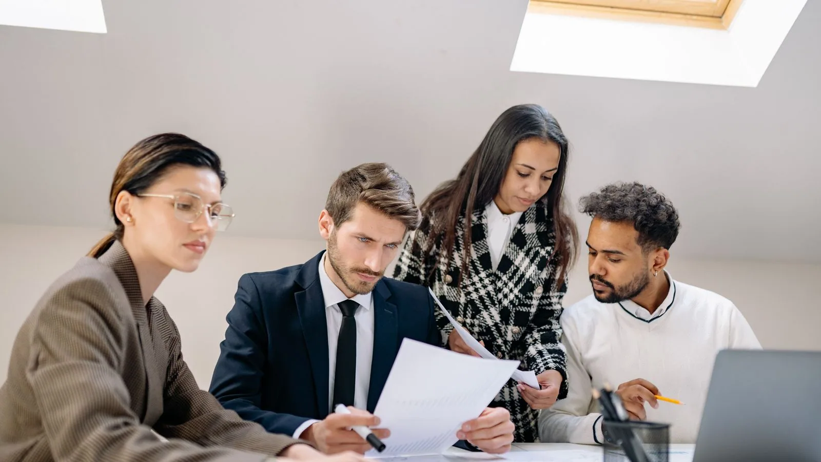 Four colleagues reviewing documents at a meeting