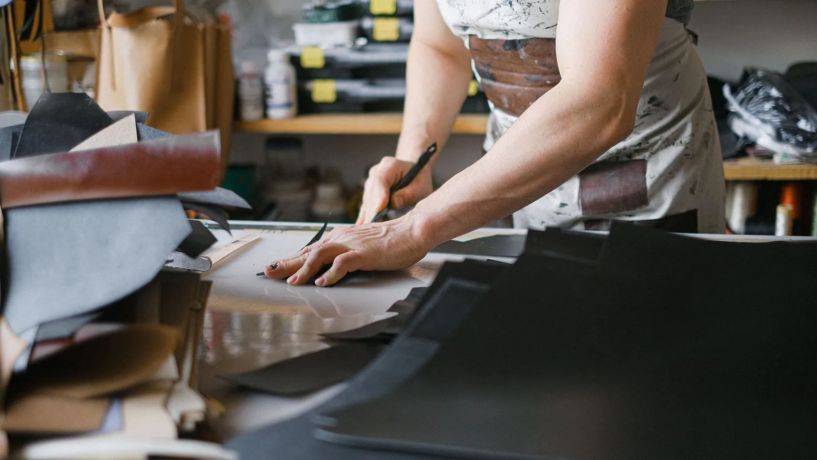 A person measuring fabric at a work table