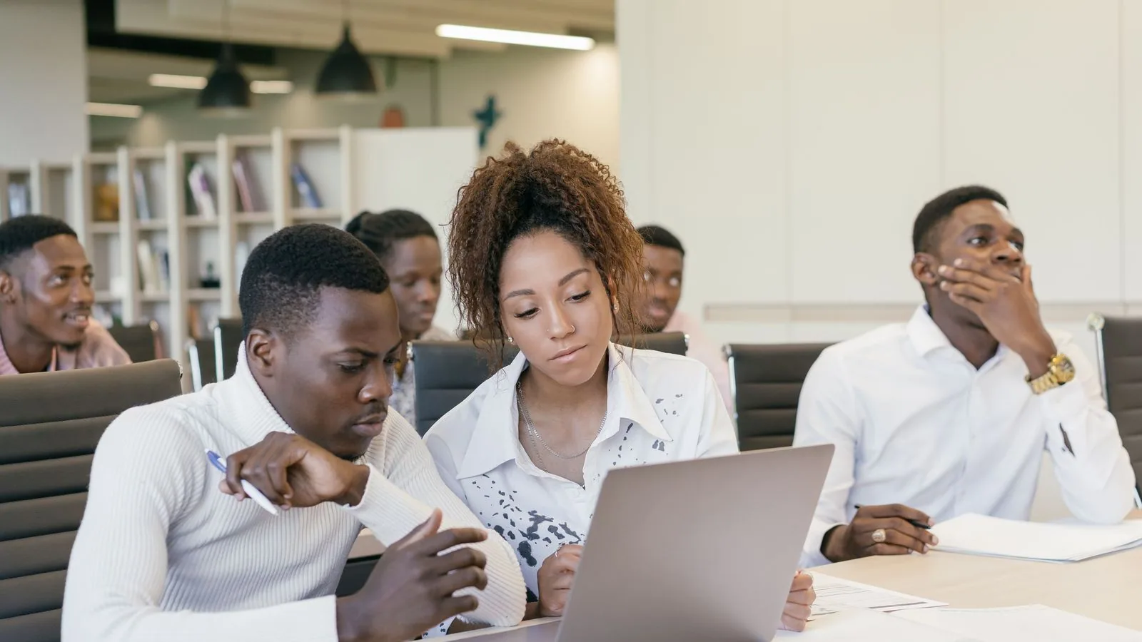 Three colleagues reviewing information on a laptop