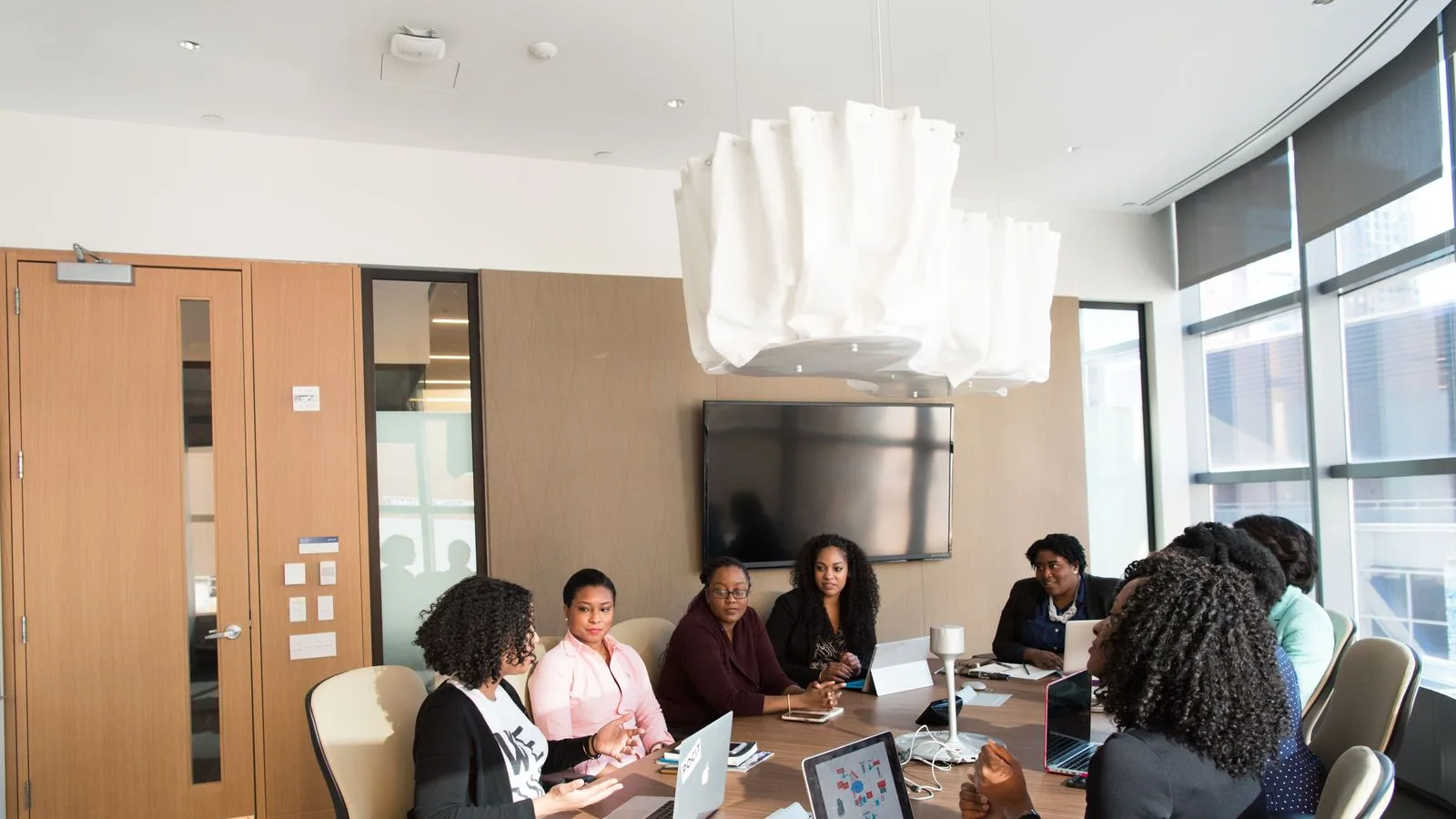 A group of colleagues working with laptops and paperwork