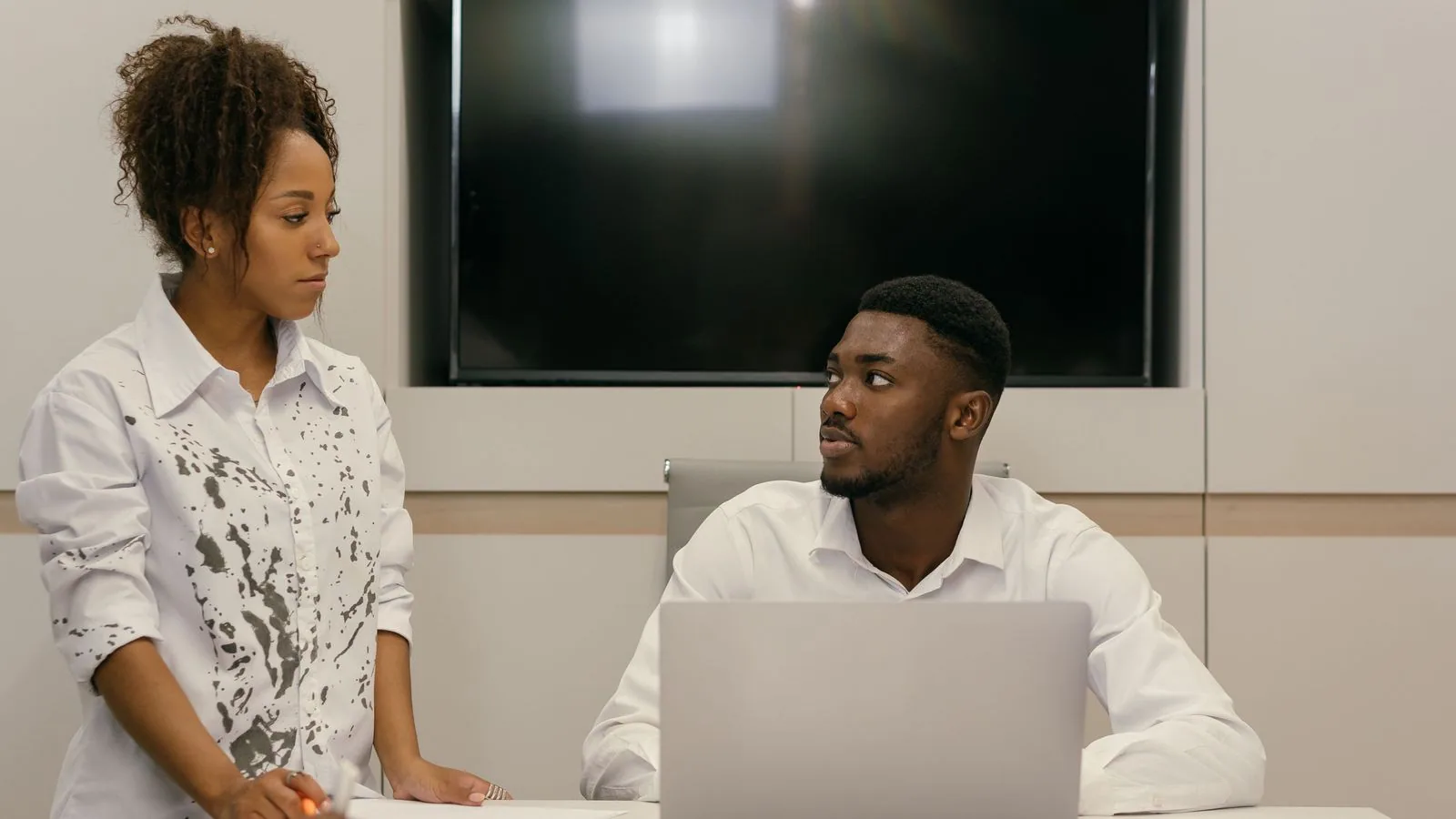 Two colleagues discussing information at a meeting table