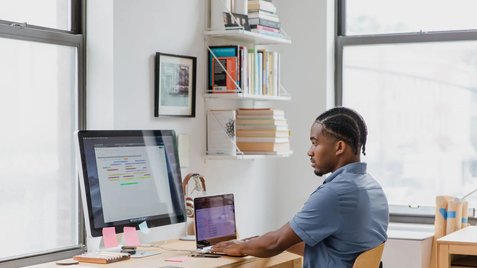 A man working at a desk with two computer screens