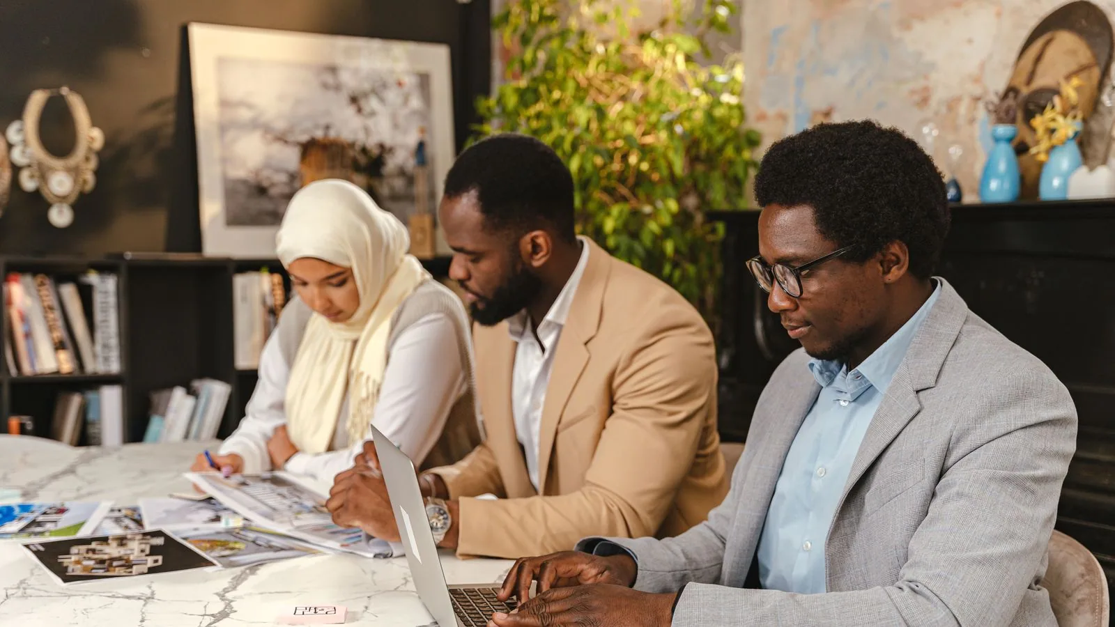 Three colleagues working with a laptop and paperwork
