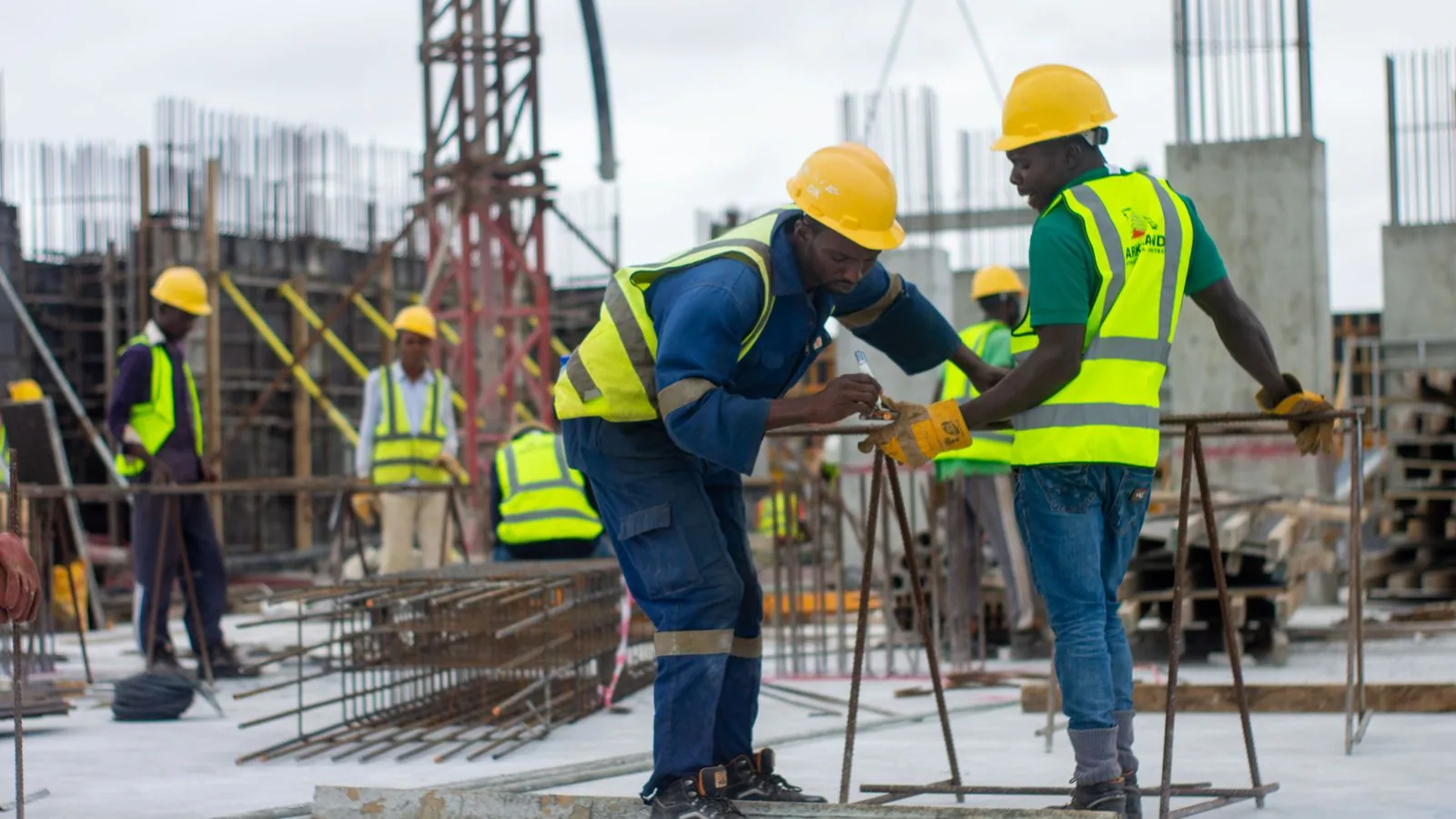 Construction workers in protective equipment checking work on site