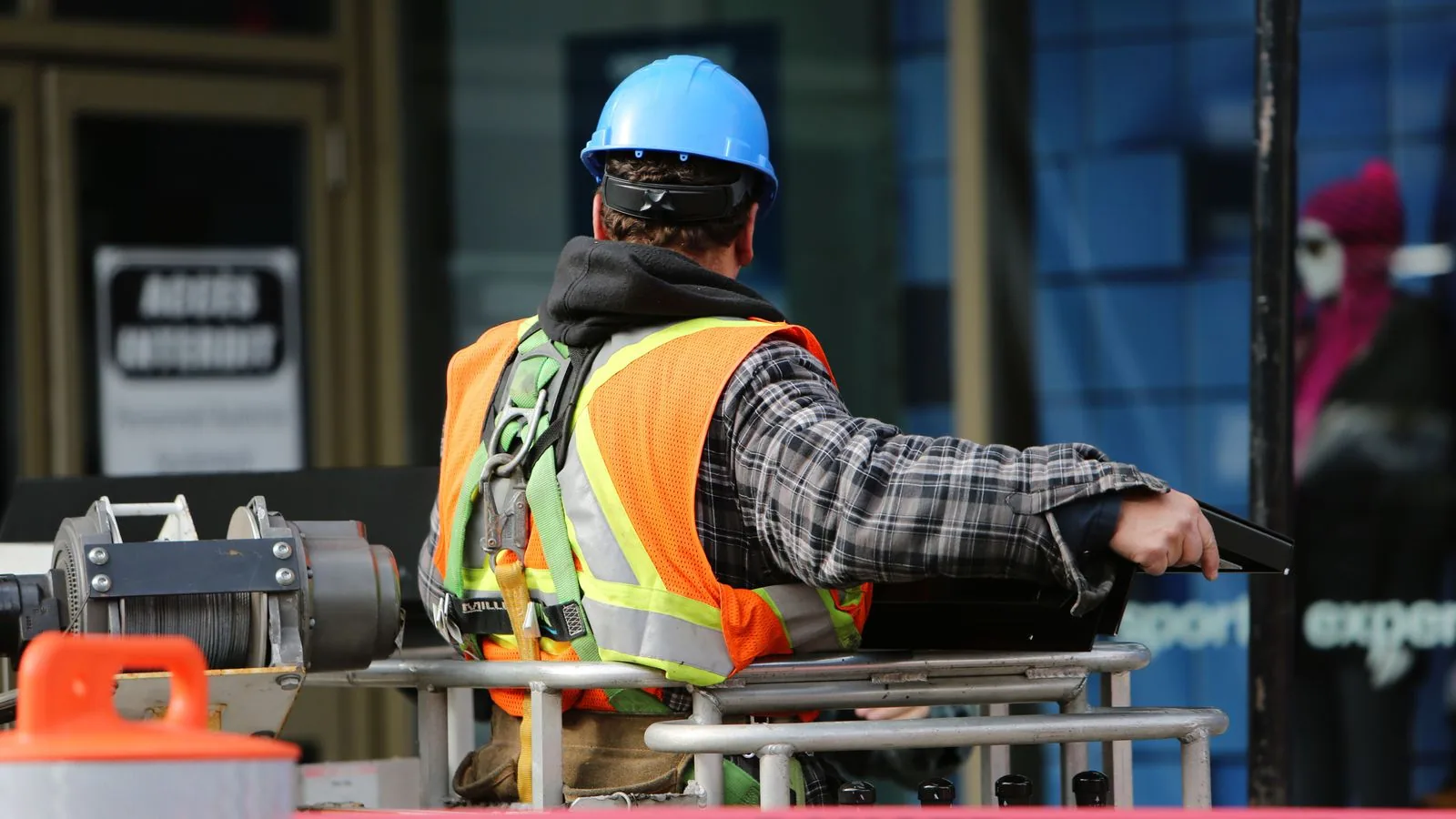 A worker in a hard hat and reflective vest at a work site