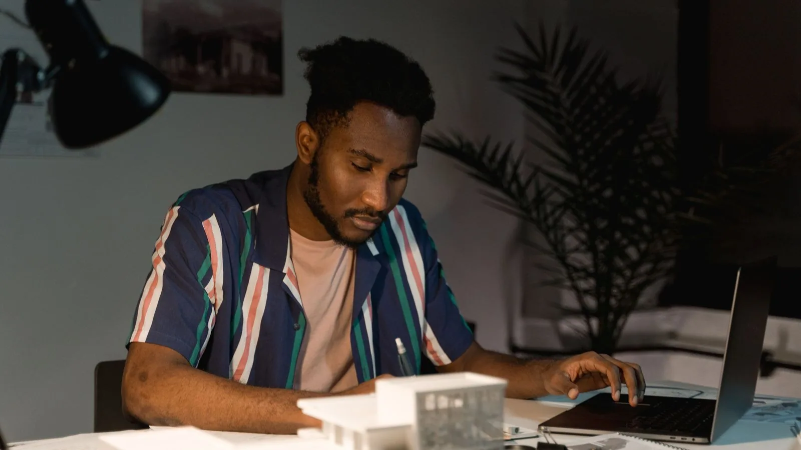 An architect working beside building models and a laptop