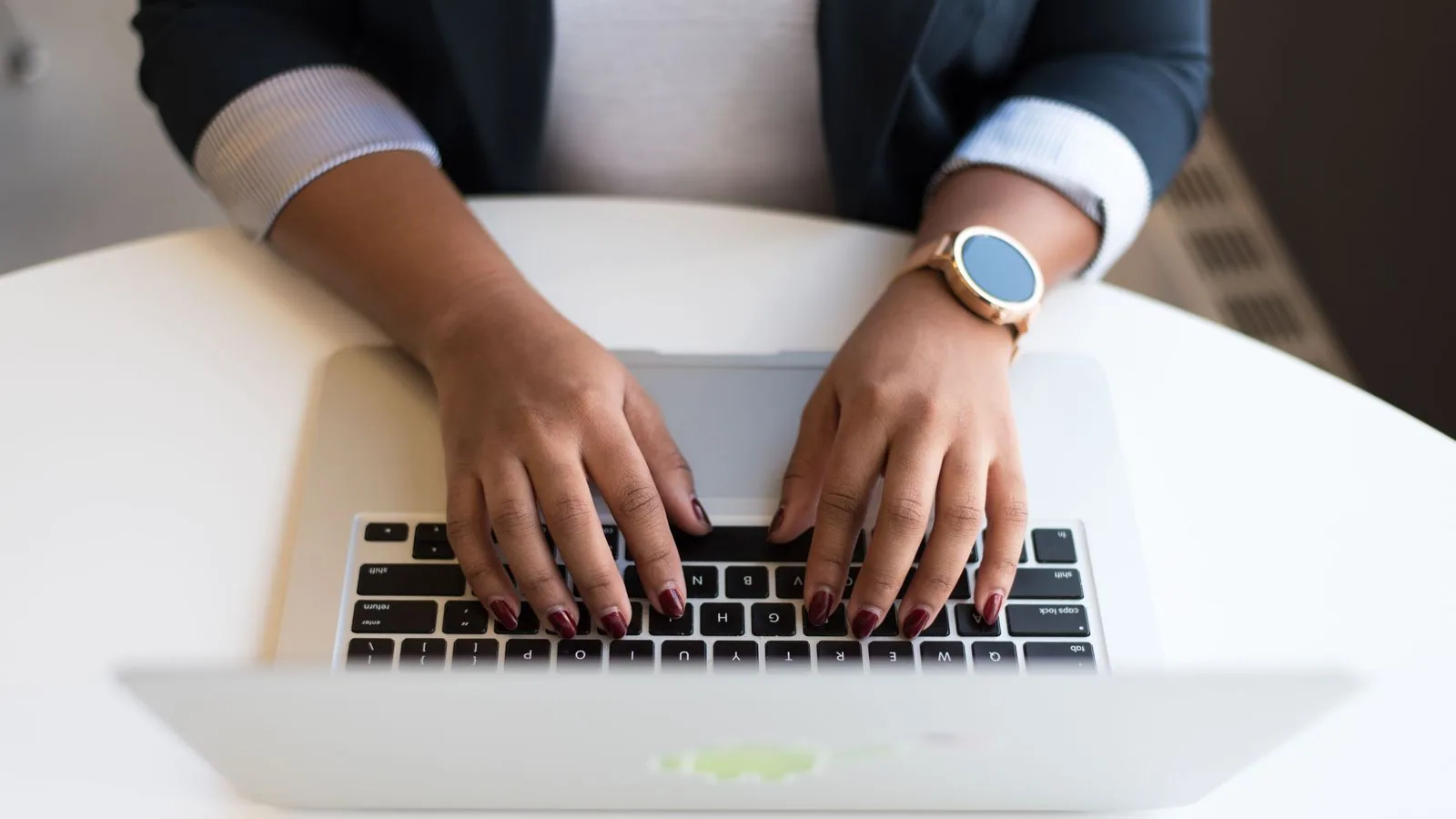 Hands typing on a laptop keyboard