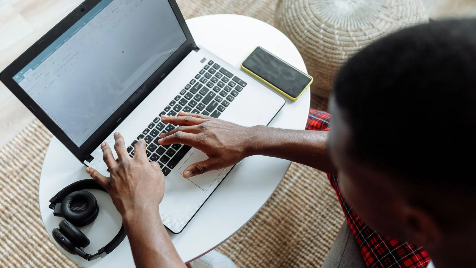 An overhead view of hands typing on a laptop
