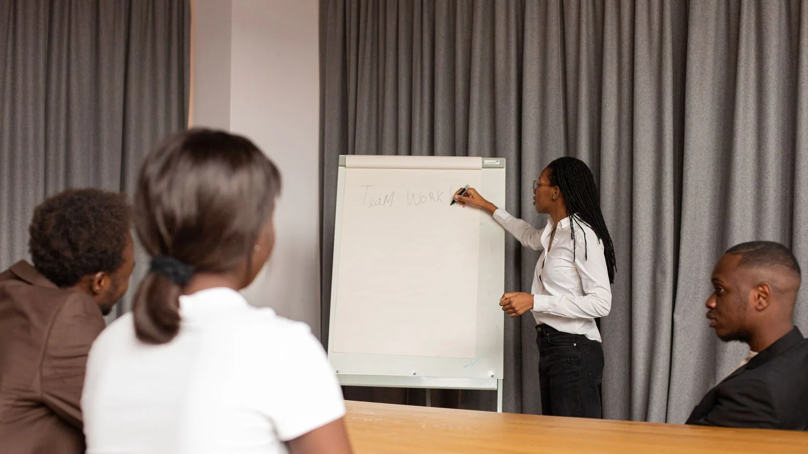 A woman presenting whiteboard notes during a meeting